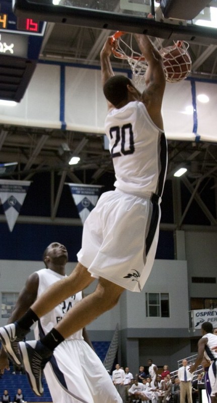 Senior forward Andy Diaz (20), who has averaged 7 ppg through three games, flushes a dunk against Edward Waters College.