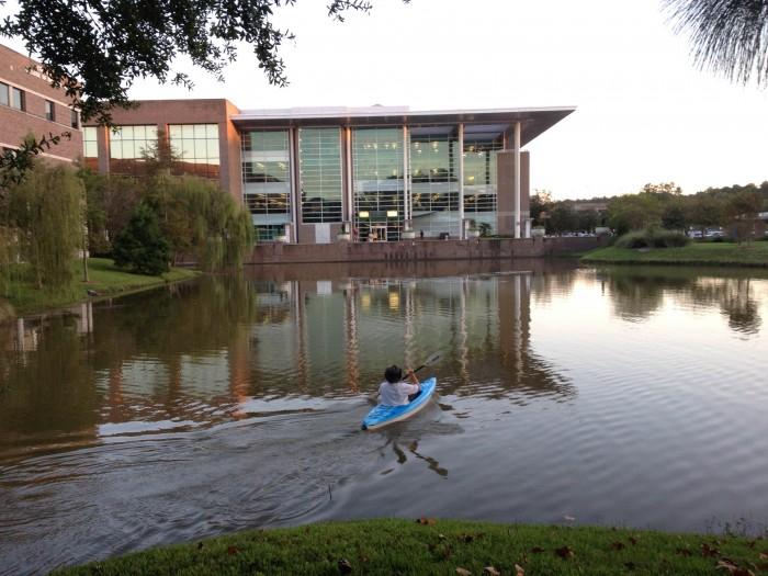 Dr. Lunberry crosses the library pond in a kayak to rearrange the lettering from Emily Dickinson's poem. Photo by Lydia Moneir