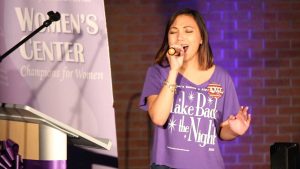 Jenniviev Gubat, a member of Alpha Chi Omega, sang "Fight Song," by Rachel Platten. Gubat replaced some of the lyrics with "take back the night song" in honor of the event. Photo by Michael Herrera