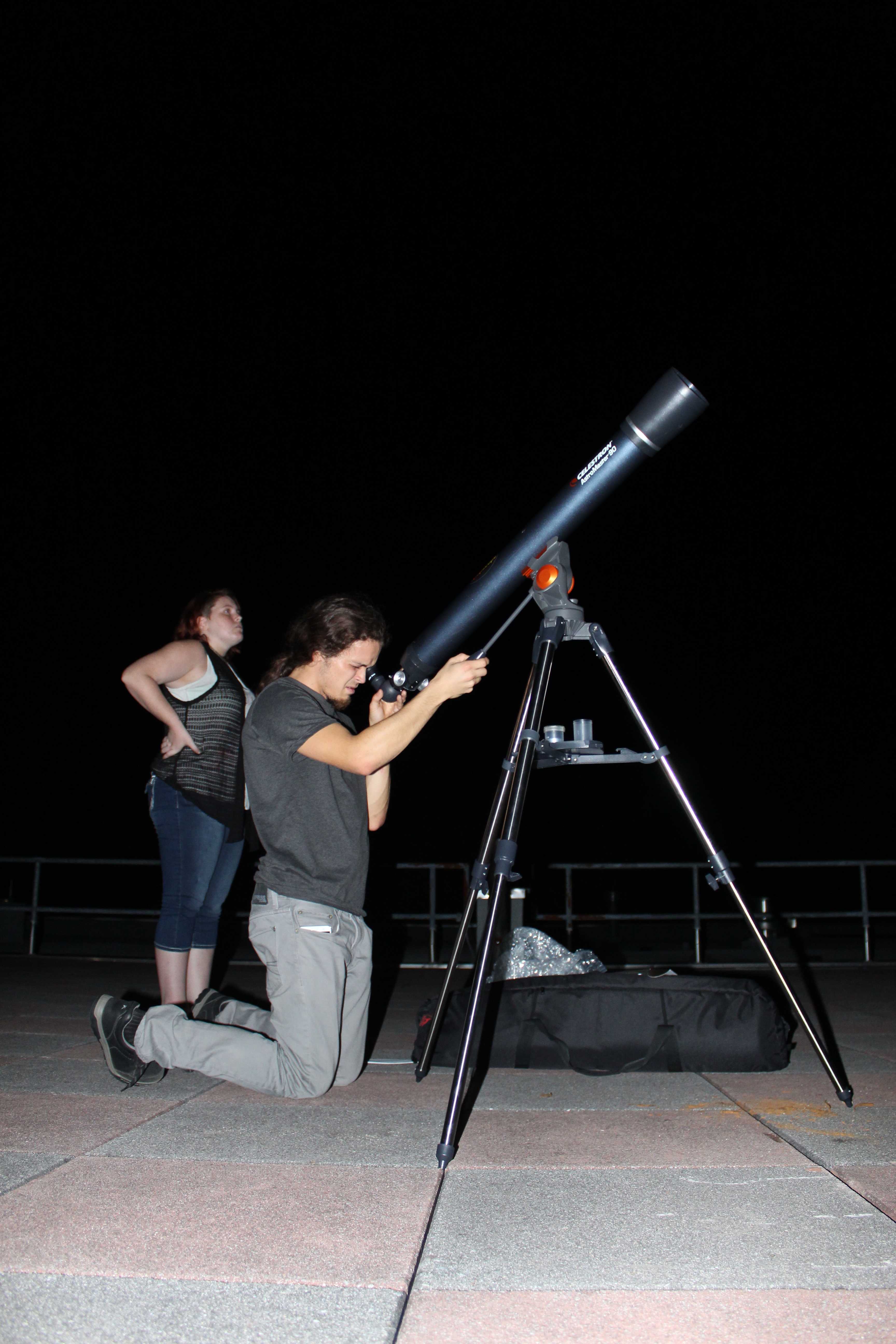 Astrophysics Professor Dr. Hewitt and Junior Astrophysics Student Shannon Silverman set up the main telescope for attendees to view nearby planets and stars. Photo by Ashley Pace