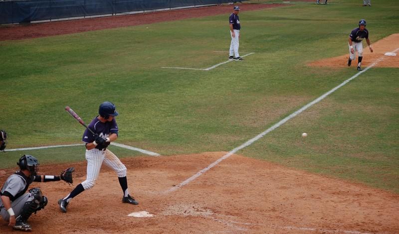 Photo Credit: Travis Gibson Drew Weeks takes a cut against NKU while Tyler Marincov waits on third base.