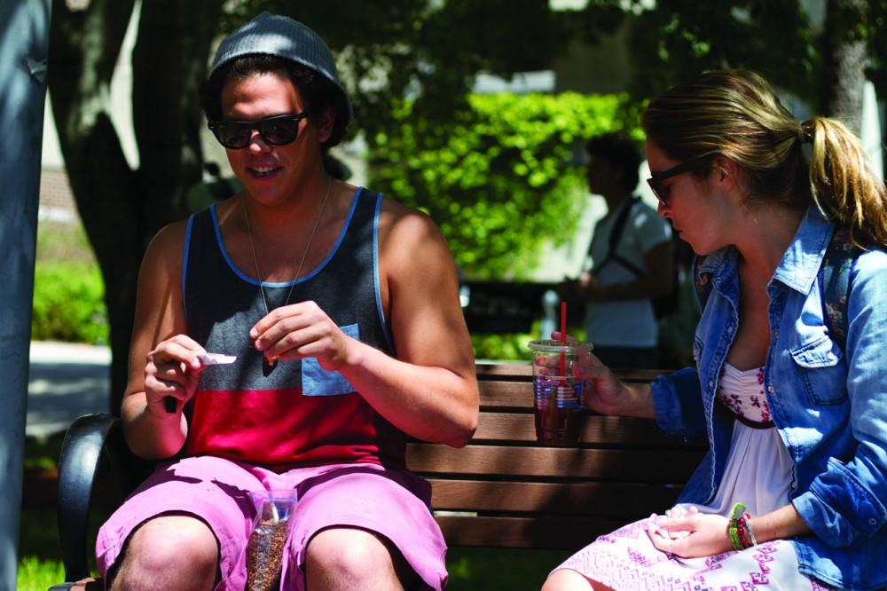 Pete Fastuca rolls his own cigarette while Paige Crofton looks on. Photo by Randy Rataj / Spinnaker