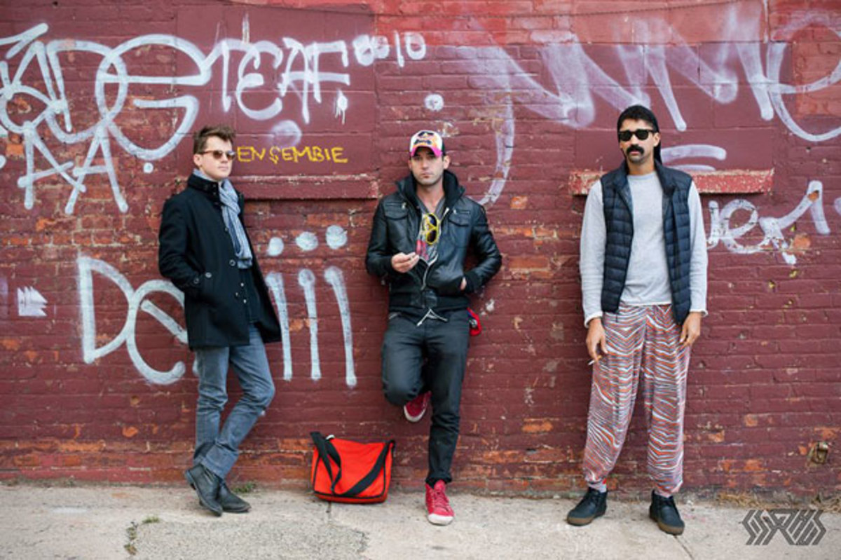 The members of Sisyphus standing in front of a graffiti'ed brick wall. Photo courtesy Facebook.