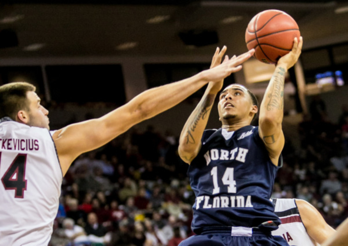UNF sophomore guard Dallas Moore puts up a shot against South Carolina Gamecocks forward Laimonas Chatkevicius.