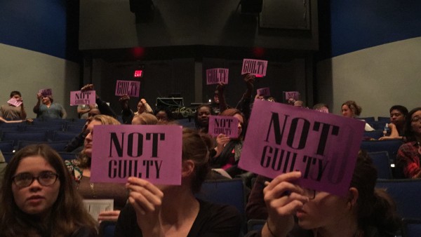 Members of the audience participate in the mock trial as a jury with "Guilty" and "Not Guilty" signs. Photo by Ashton Elder