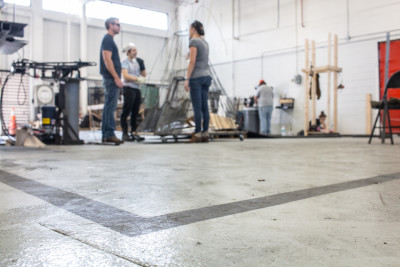 In the metal shop of the new UNF sculpture lab, the dimensions of the old sculpture lab are taped on the floor to remind the students of the old space they used to work in.  Photo by Michael Herrera