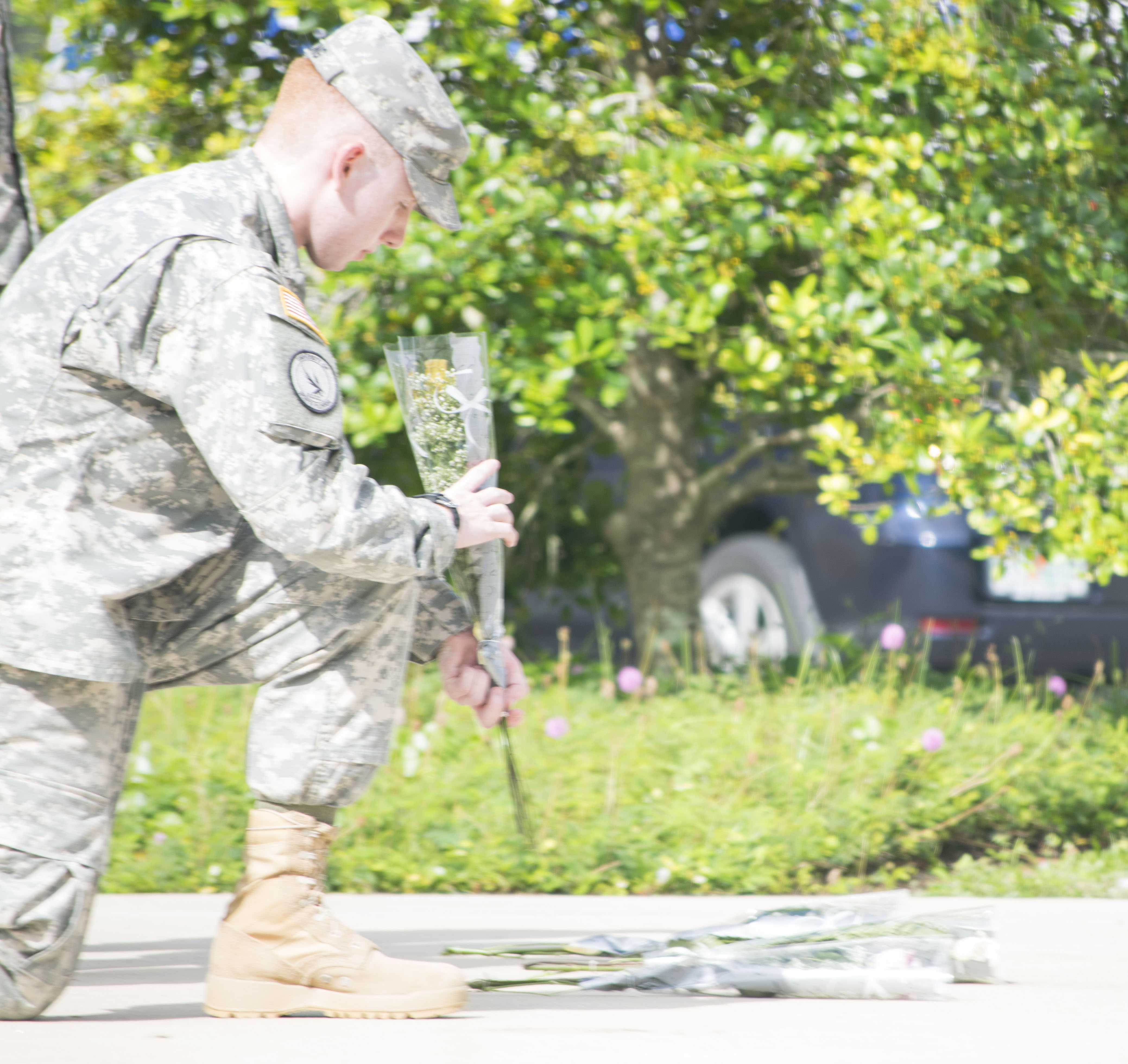 Cadet Cpl. Adam Young, criminal justice sophomore, lays down a rose beneath the United States flag. 

Photo by Christian Ayers