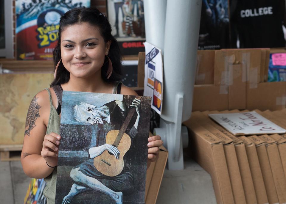 Tahmia Karem presents a print of Picasso’s “The Old Guitarist,” one of her favorite pieces of art.  Photo by Michael Herrera