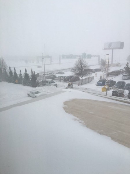 A bulldozer clears snow outside of 