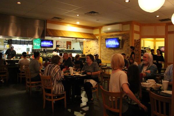 Customers engage in upbeat conversations surrounded by sounds from the grill, sushi bar, radio and discussions at neighboring tables. Photo by Courtney Stringfellow. 