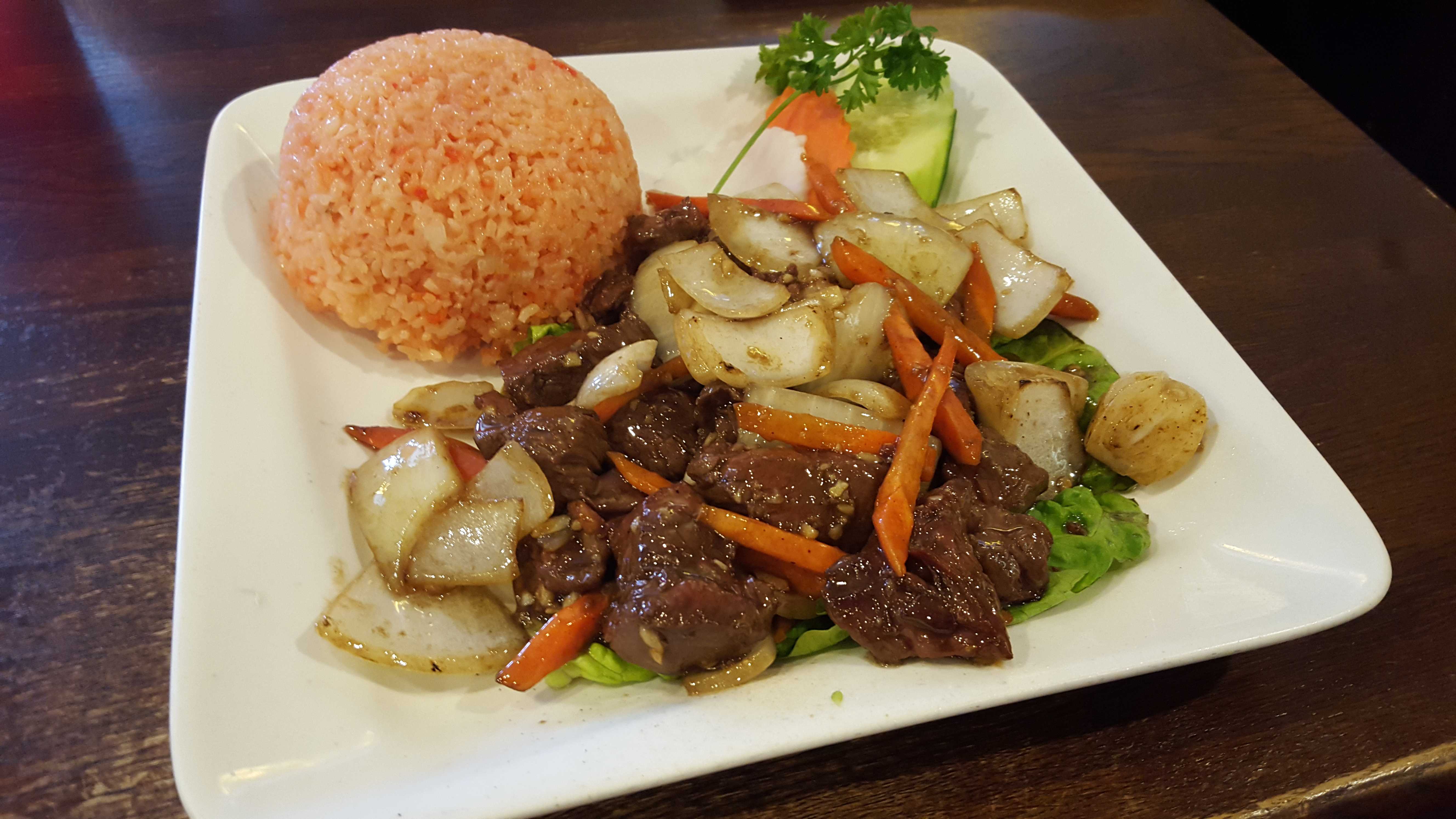 The shaken beef dish features chopped beef, onions and carrots seasoned with a house sauce. The soft and sticky red rice is simply fried rice. Photo by Courtney Stringfellow