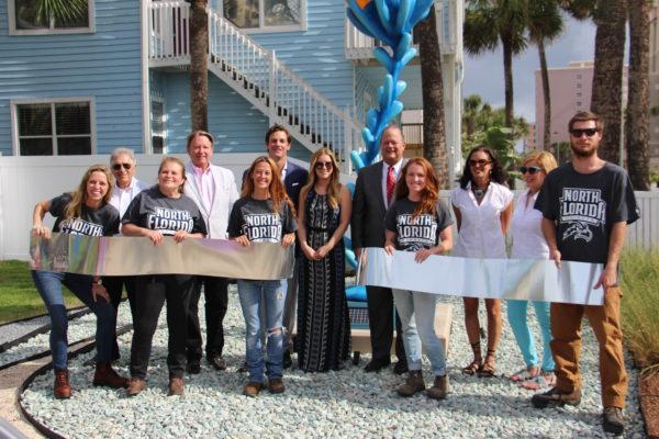 UNF President John Delaney and a representative from the Lazzara Family Foundation strike a pose with the five student artists. Photo by Brittany Moore.