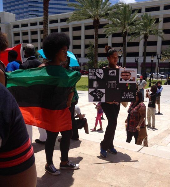 Hulbyu Sincler stands with her pan-african flag. Photo by Danae Leake.