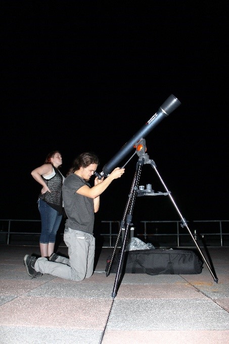Astrophysics Professor Dr. Hewitt and Junior Astrophysics Student Shannon Silverman set up the main telescope for attendees to view nearby planets and stars. Photo by Ashley Pace