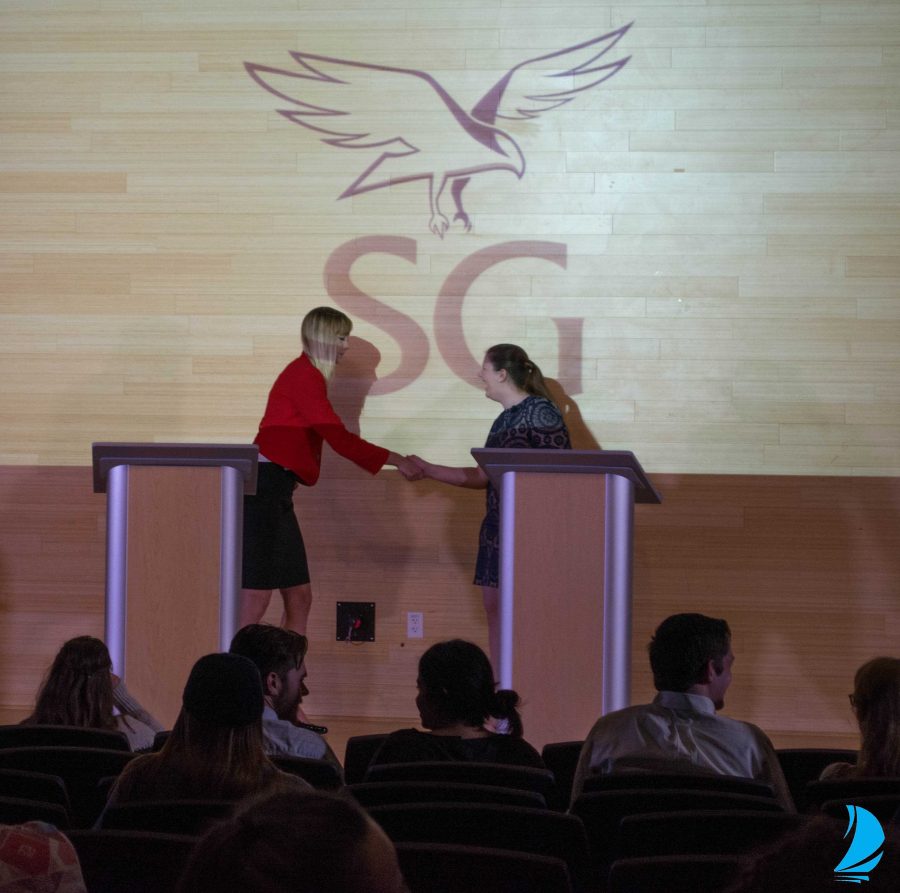 Candidates shake hands at the SG presidential debate. Photo by Lili Weinstein