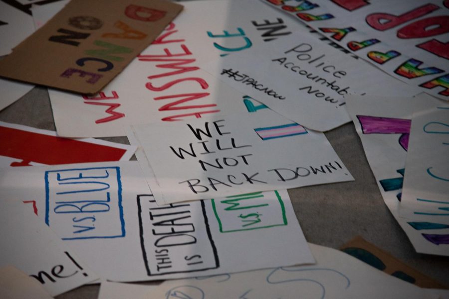 A 'We will not back down" sign among a pile of others used during the vigil.