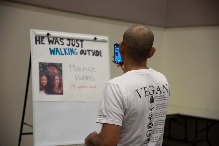 Attendee looks at posters before the town hall meeting.