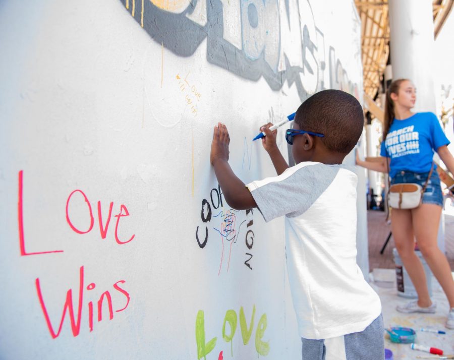 A young child adds to the board on what the community believes change looks like.