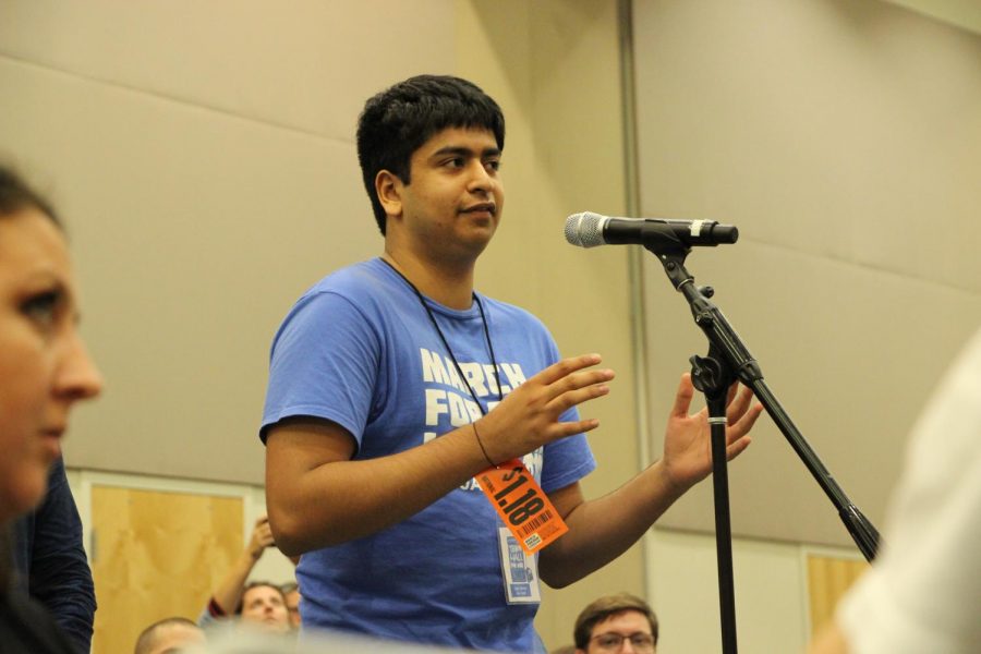 Young adult asking a question to the panelists. 