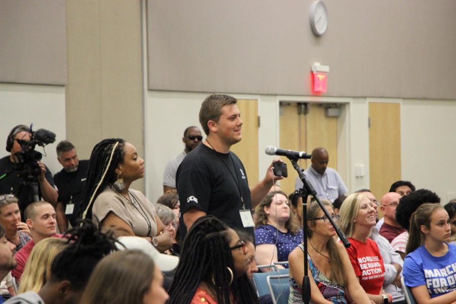 Staff member of the Utah Gun Exchange asking the panelists a question.