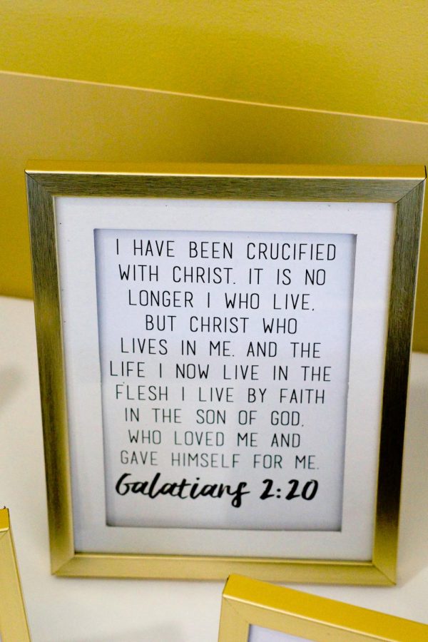 Framed bible verse displayed on table.