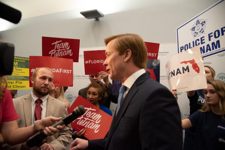 Adam Putnam and an array of signs in support of him.