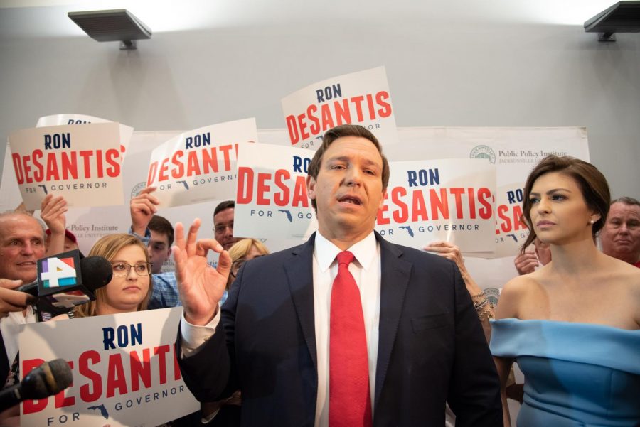 Ron DeSantis answering press questions with his wife, Casey Black DeSantis, by his side.