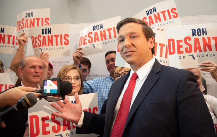 Ron DeSantis answers questions for the press with his supporters by his side.