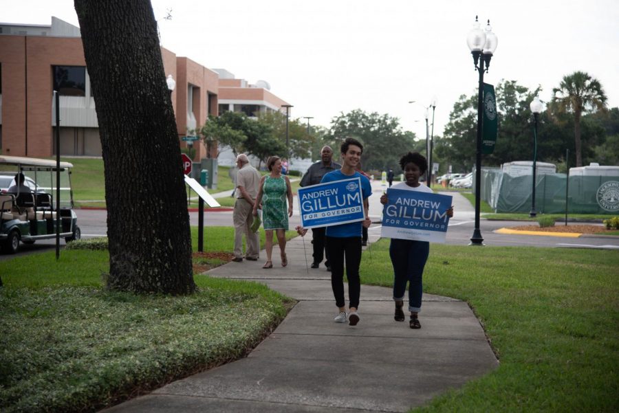Supporters hold up signs for Andrew Gillum on their way to Terry Concert Hall
