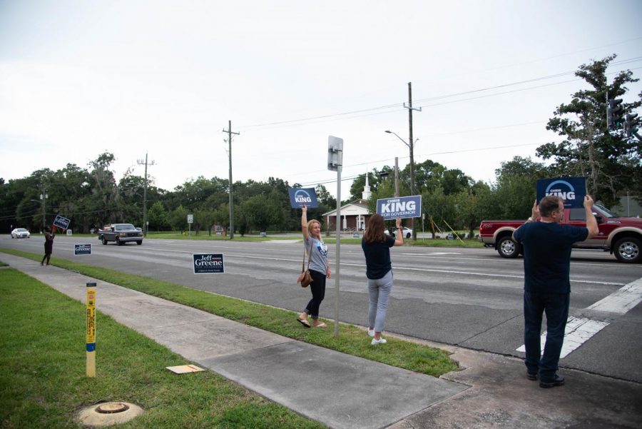 Supporters of Chris King hold up signs on University Blvd 