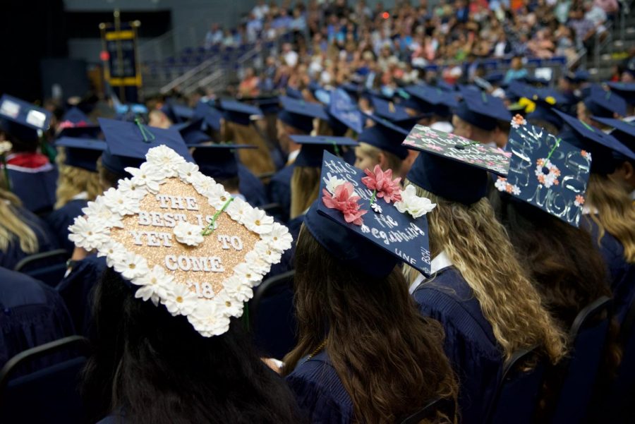 Graduates displaying their customized caps.