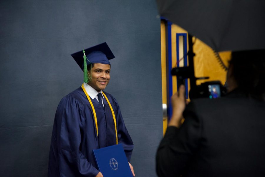 A graduate posing for a picture after completing his walk across the stage.