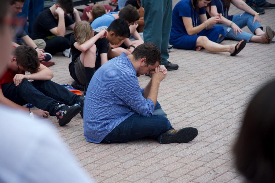 Attendee praying for the lives lost in The Landing shooting.