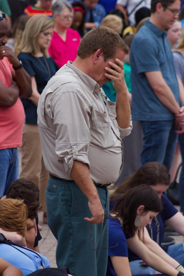 Attendee showing respect for the lives lost in The Landing shooting.
