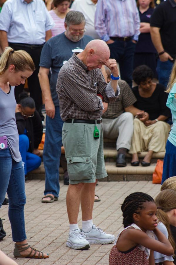 Attendee  showing respect for the lives lost in The Landing shooting.