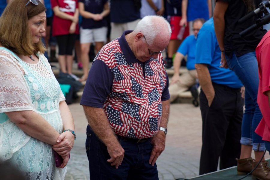 Attendee showing respect for the lives lost in The Landing shooting.