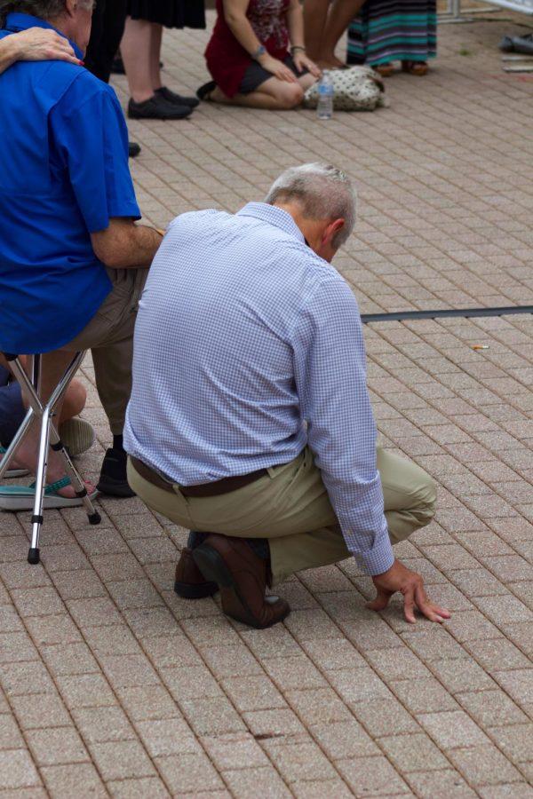 Attendee showing respect for the lives lost in The Landing shooting.