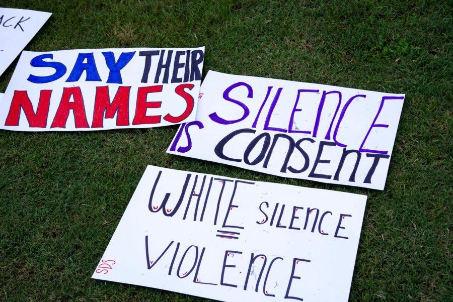 Signs stating "Say their names", "Silence is consent", and "White silence violence".