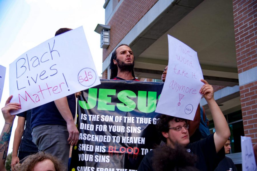 Attendees holding signs in front of counter protester.