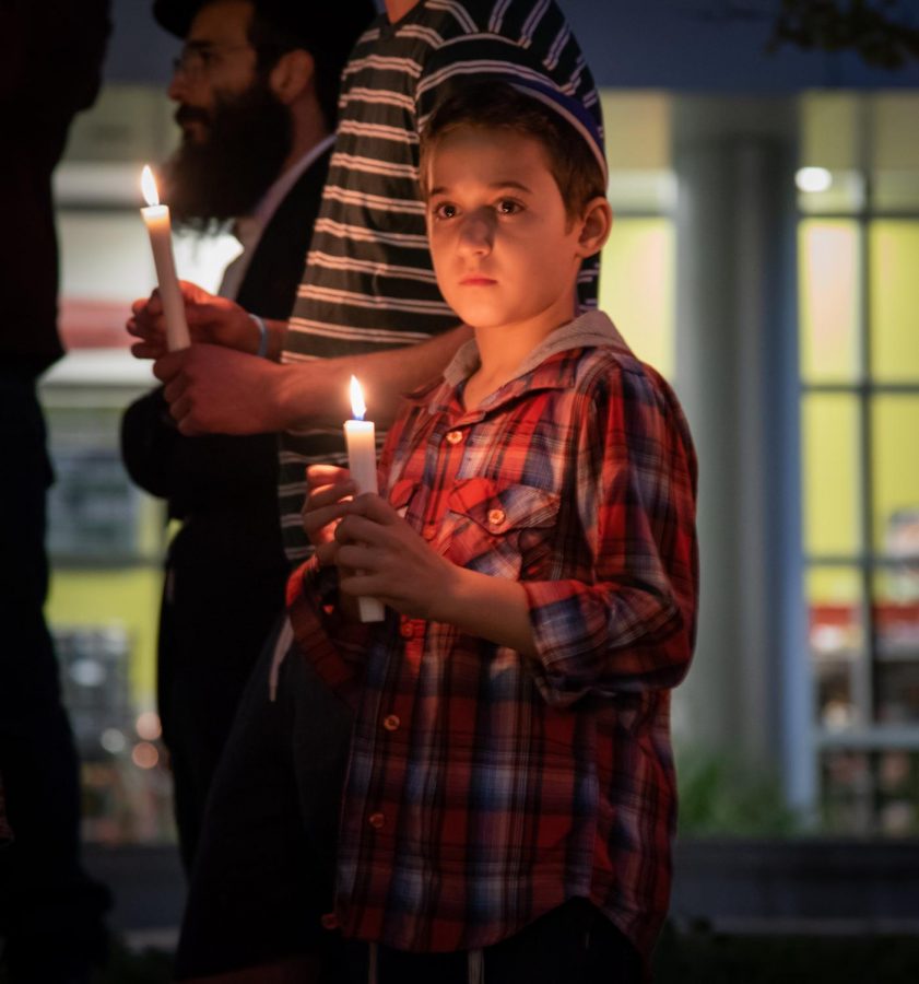 Child holding candle at vigil.