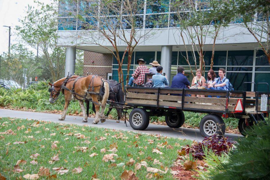 Horse drawn carriage pulling taking students on a ride.