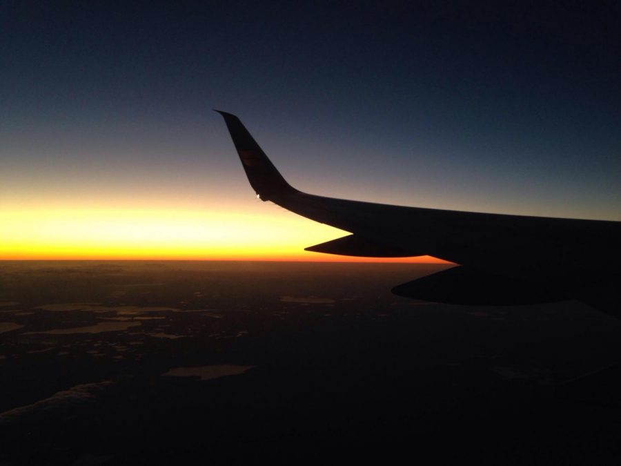 The wing of a plane in front of a sunset.