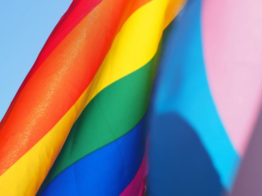 LGBTQ+ flags against blue sky.