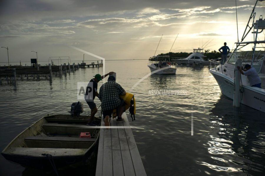 People arrive to a private harbor to move boats away for protection ahead of the arrival of Tropical Storm Dorian in Boqueron, Puerto Rico, Tuesday, Aug. 27, 2019. (AP Photo/Ramon Espinosa)