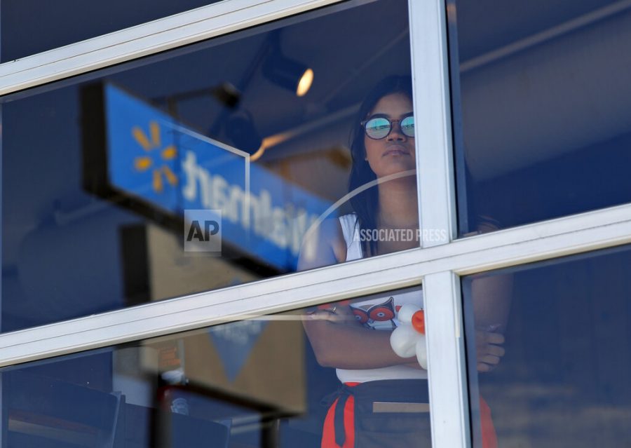 A restaurant employee looks at the scene of a mass shooting at a shopping complex Sunday, Aug. 4, 2019, in El Paso, Texas. (AP Photo/John Locher)