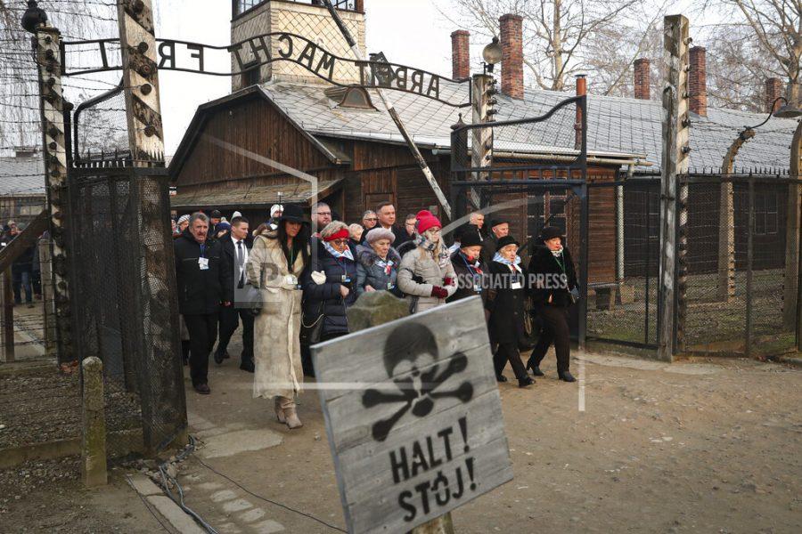 Polands President Andrzej Duda walks along with survivors through the gates of the Auschwitz Nazi concentration camp to attend the 75th anniversary of its liberation in Oswiecim, Poland, Monday, Jan. 27, 2020. (AP Photo/Czarek Sokolowski)
