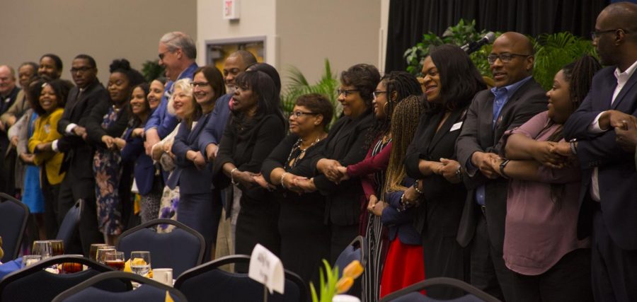 Rev. Webb demonstrates the love chain with attendees. Photo credit Christian Ayers.