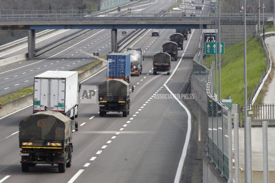 Military trucks moving coffins of deceased people line up on the highway next to Ponte Oglio, near Bergamo, one of the areas worst hit by the coronavirus infection, on their way from Bergamo cemetery to a crematory in some other location as the local crematory exceeded its maximum capacity, Thursday, March 26, 2020. The new coronavirus causes mild or moderate symptoms for most people, but for some, especially older adults and people with existing health problems, it can cause more severe illness or death. (AP Photo/Luca Bruno)