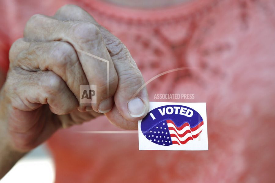 FILE - In this March 17, 2020, file photo Fran Drago shows her sticker after she voted in the Florida presidential primary in Cape Coral, Fla. Scrambling to address voting concerns amid a pandemic, election officials from Nevada to Florida are scaling back or eliminating opportunities for people to cast ballots in person. (AP Photo/Elise Amendola, File)