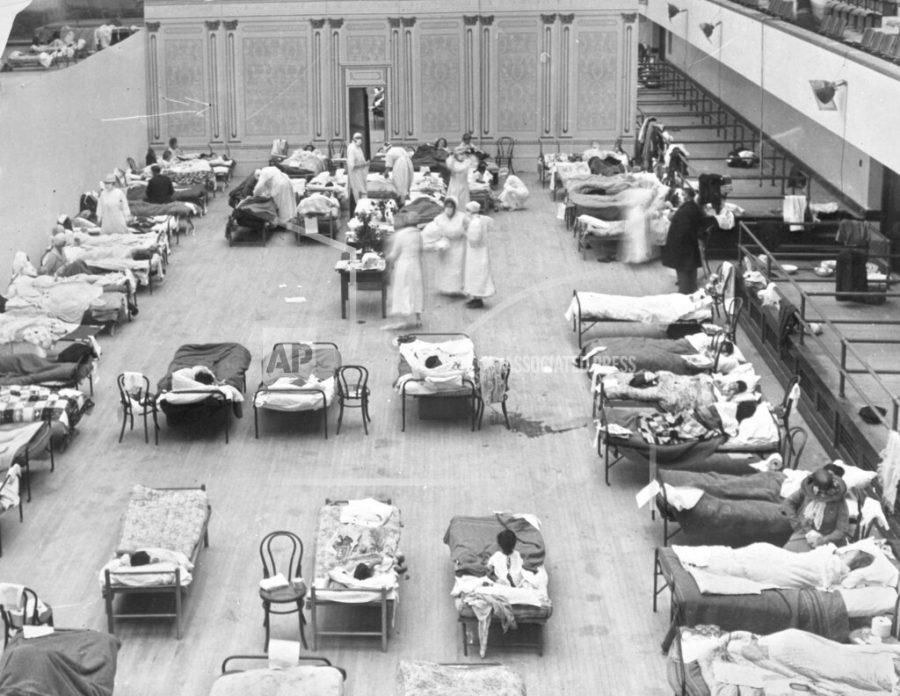 FILE - In this 1918 file photo made available by the Library of Congress, volunteer nurses from the American Red Cross tend to influenza patients in the Oakland Municipal Auditorium, used as a temporary hospital. Science has ticked off some major accomplishments over the last century. The world learned about viruses, cured various diseases, made effective vaccines, developed instant communications and created elaborate public-health networks. Yet in many ways, 2020 is looking like 1918, the year the great influenza pandemic raged. (Edward A. Doc Rogers/Library of Congress via AP, File)